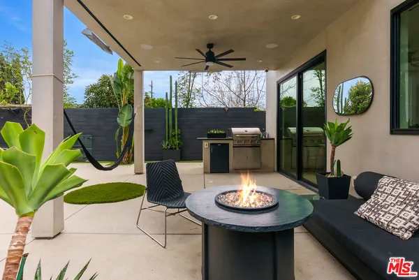 a view of a patio with table and chairs under an umbrella