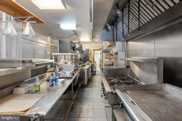 a kitchen with a stove a refrigerator and a dining table