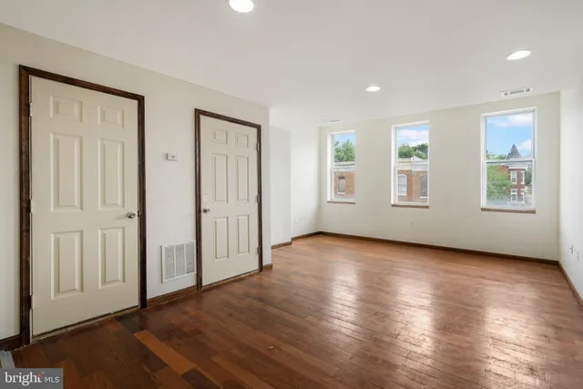 an empty room with wooden floor and fireplace