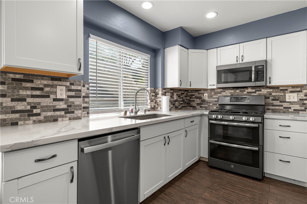 15417 Tobarra Road Fontana, CA 92337 - Photo 13 of 29 a kitchen with stainless steel appliances a stove sink microwave and cabinets