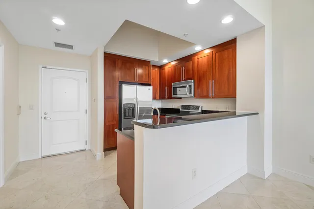 a kitchen with stainless steel appliances granite countertop a stove microwave and sink