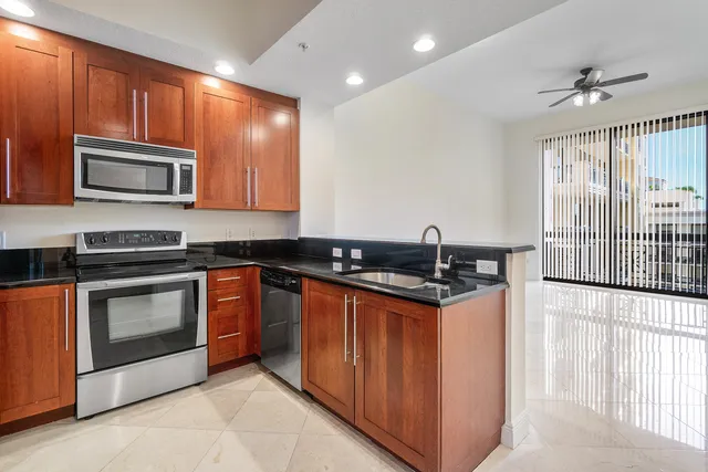 a kitchen with stainless steel appliances granite countertop a stove a microwave and a sink