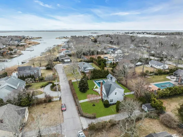 an aerial view of a house with a swimming pool and lake view