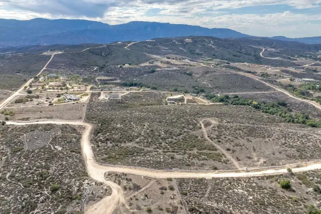 a view of a dry yard with mountains in the background