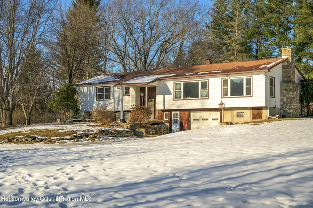 a front view of a house with a yard covered in snow
