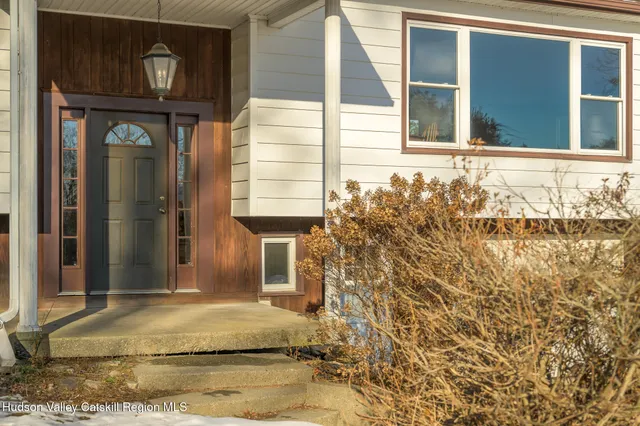 a view of a hallway with wooden floor and entryway