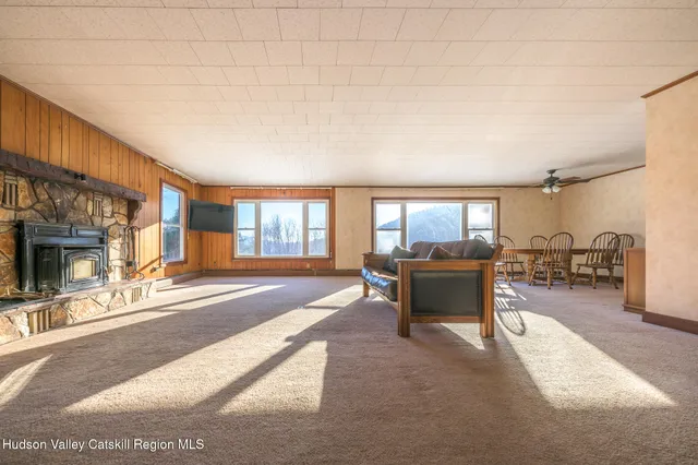 a living room with furniture a fireplace and large windows