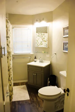 a bathroom with a toilet sink and mirror