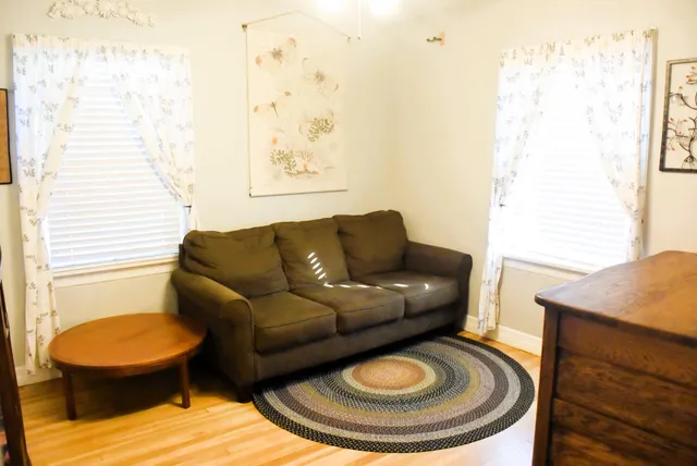 a living room with furniture a rug and a window
