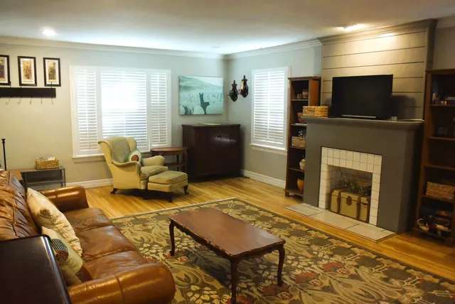 a living room with furniture a flat screen tv and a fireplace