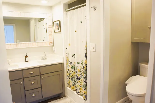 a bathroom with a sink a toilet and shower