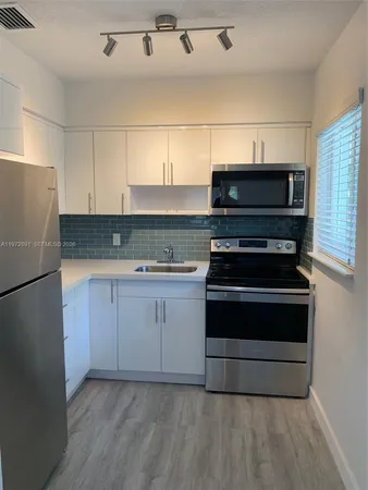 a kitchen with granite countertop a stove and a refrigerator