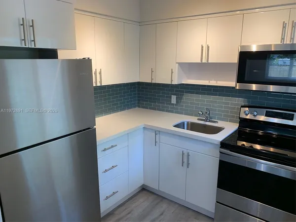 a kitchen with a refrigerator and a sink