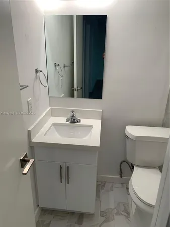 a bathroom with a sink toilet and mirror