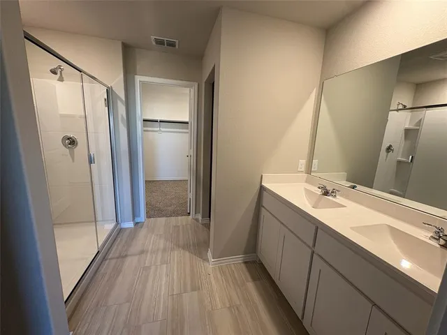 a bathroom with a double vanity sink and mirror