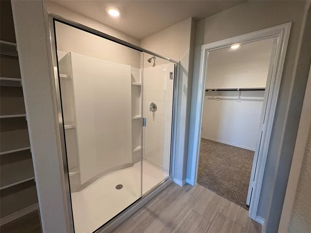 a bathroom with a glass door shower and a mirror