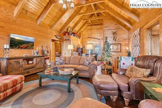 a living room with furniture a rug and a fan