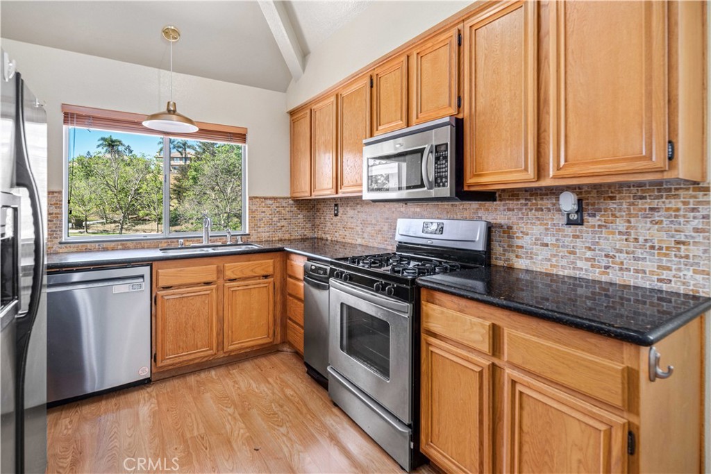 498 Shelburne Lane, Unit B Simi Valley, CA 93065 - Photo 16 of 47 a kitchen with stainless steel appliances granite countertop a stove a sink and a microwave