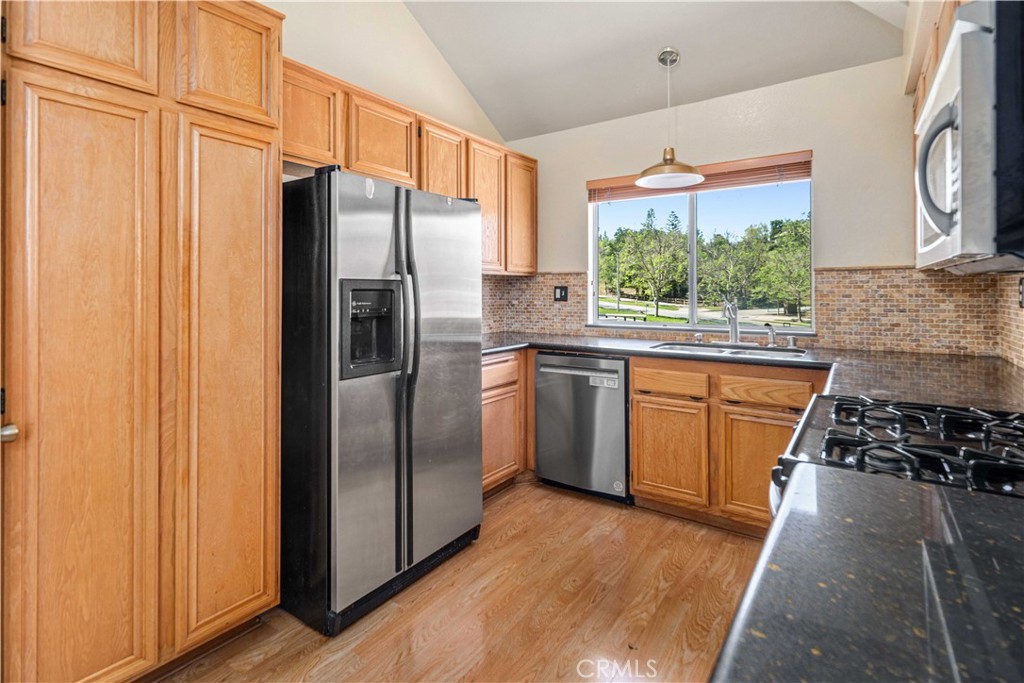 498 Shelburne Lane, Unit B Simi Valley, CA 93065 - Photo 18 of 47 a kitchen with stainless steel appliances granite countertop a refrigerator a sink dishwasher a stove with wooden floor and cabinets