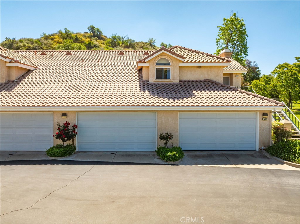 498 Shelburne Lane, Unit B Simi Valley, CA 93065 - Photo 33 of 47 a front view of a house with a yard and garage