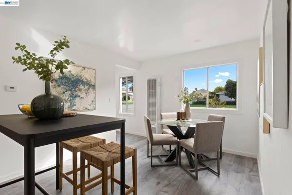 a dining room with furniture and potted plants