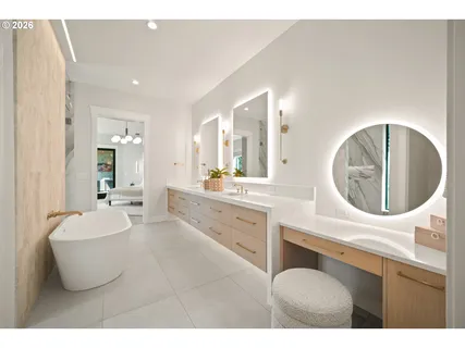 a living room with furniture a mirror and white walls