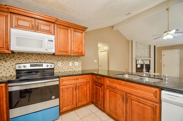 a kitchen with granite countertop cabinets stainless steel appliances and a sink