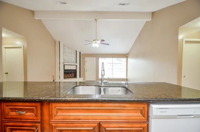 a kitchen with granite countertop a sink and a window