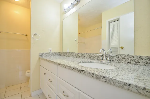 a bathroom with a granite countertop sink and a mirror