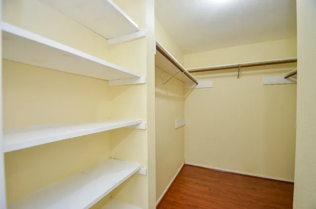 a view of walk in closet with wooden floor
