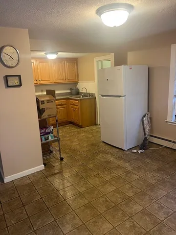 a view of a refrigerator and more cabinets in a room