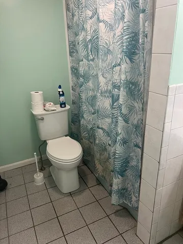 a white toilet sitting next to a shower