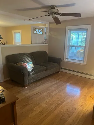 a living room with furniture and a wooden floor