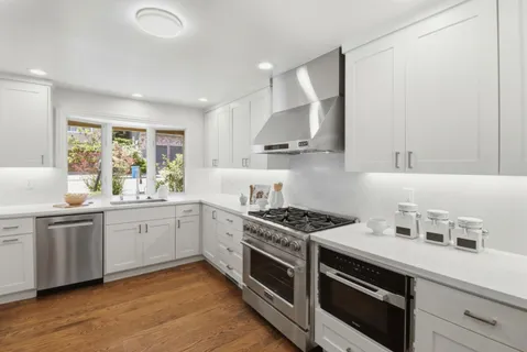 a kitchen with stainless steel appliances a stove a sink and a refrigerator