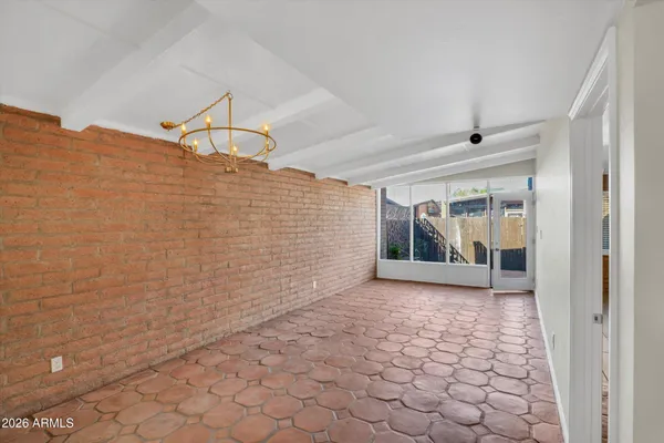 a view of an empty room and a kitchen