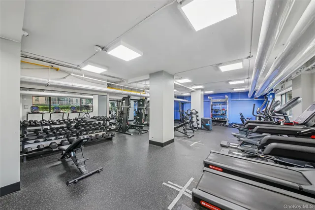 a room with gym equipment and large windows