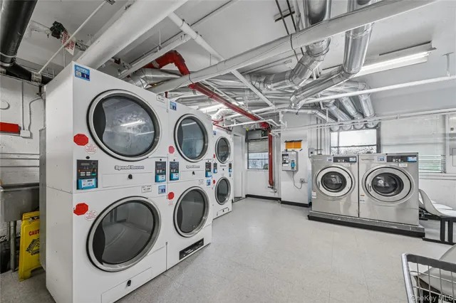 a utility room with dryer washer and a view of kitchen