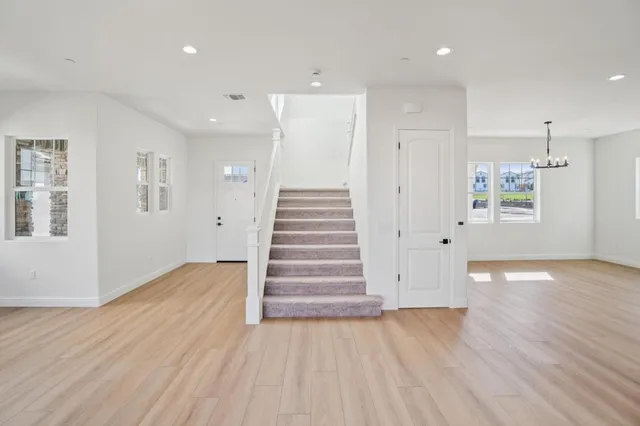 a large white kitchen with wooden floor and a sink