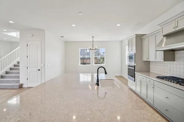 a kitchen with a sink stove and wooden floor