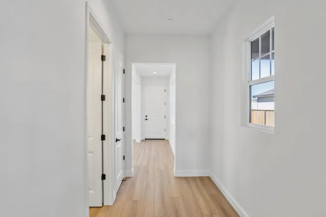 a big room with wooden floor closet and windows