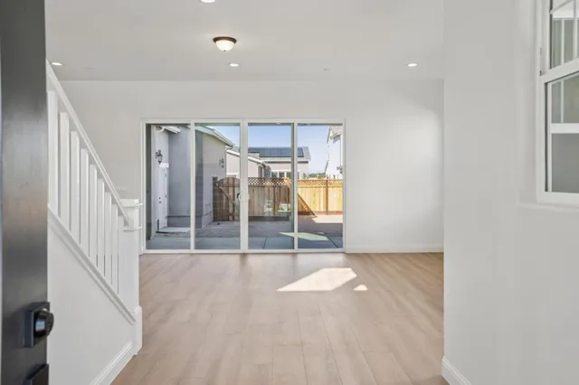 a view of a kitchen with wooden floor and windows