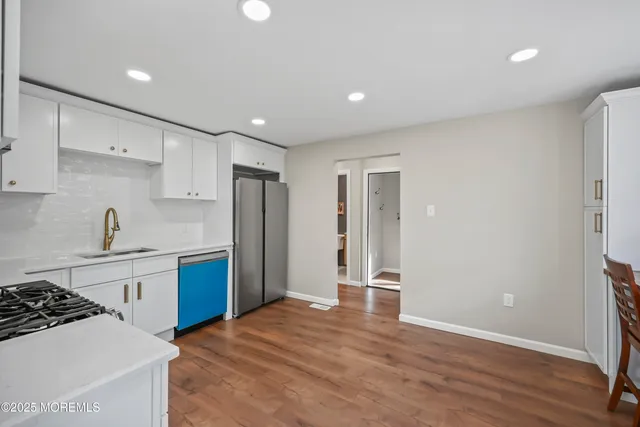 an empty room with wooden floor chandelier fan and windows