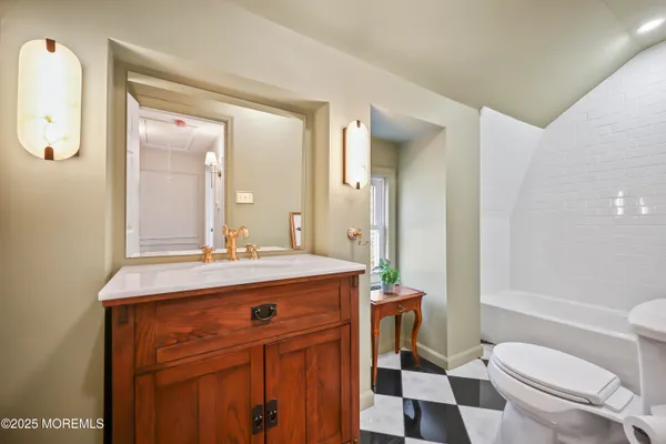 an empty room with wooden floor chandelier fan and windows