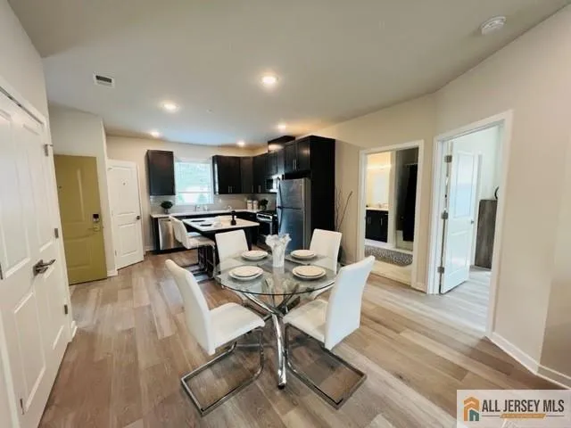 a kitchen with stainless steel appliances kitchen island granite countertop a refrigerator and a stove top oven