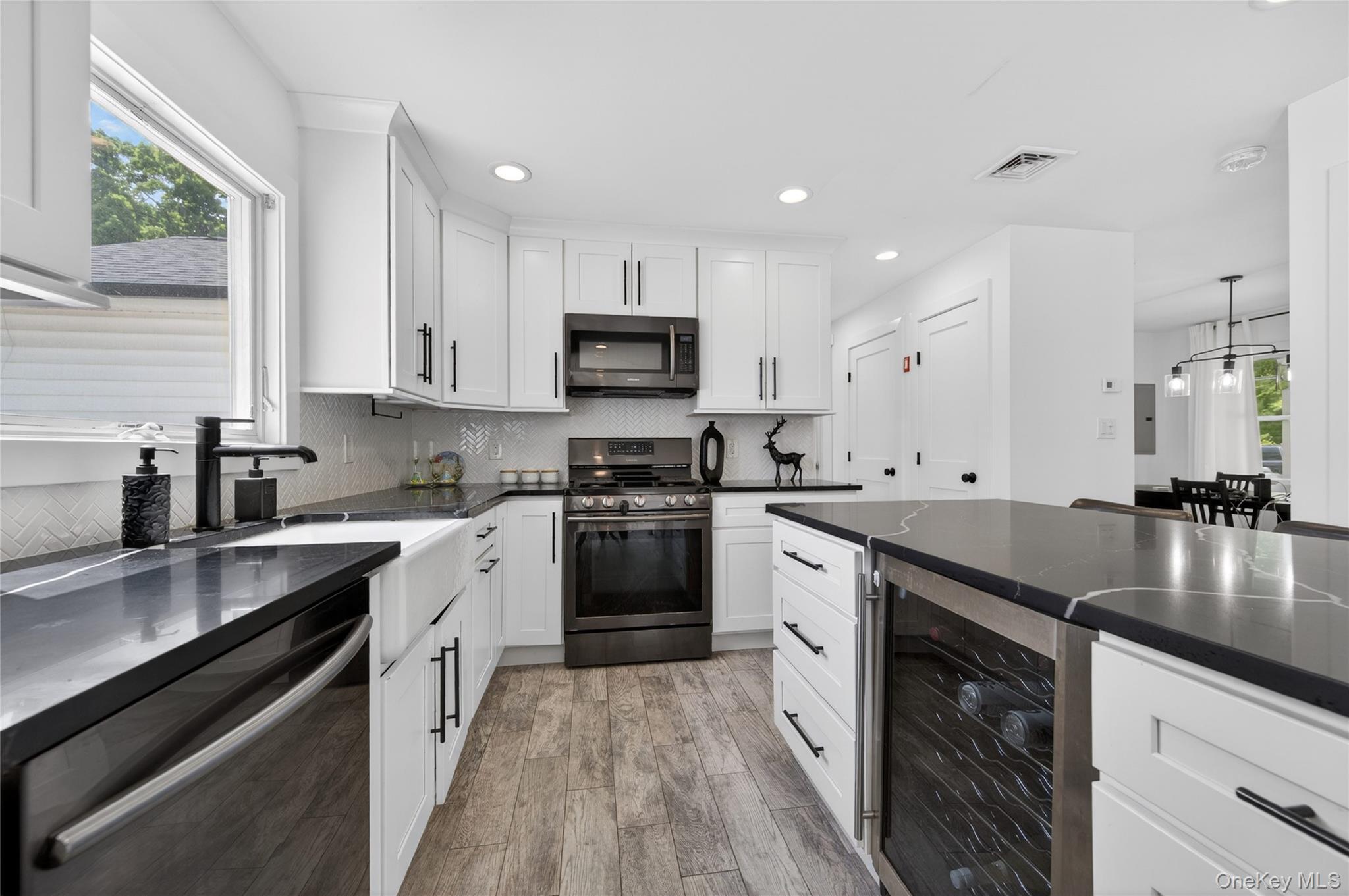 534 Riverside Avenue Massapequa, NY 11758 - Photo 8 of 28 a kitchen with stainless steel appliances granite countertop a sink a stove top oven a counter space and cabinets
