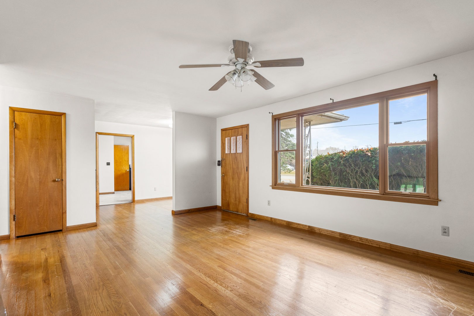 904 West Kirby Avenue Champaign, IL 61821 - Photo 9 of 46 a view of an empty room with a window and wooden floor
