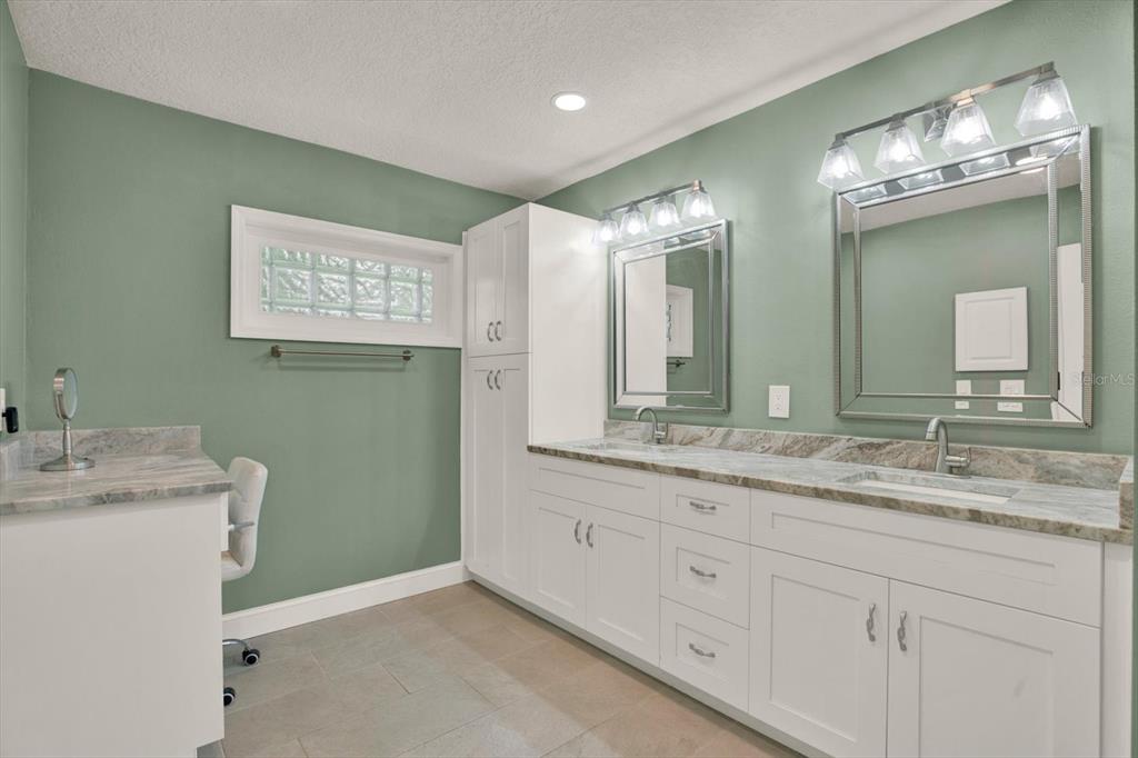7487 River Country Drive Weeki Wachee, FL 34607 - Photo 30 of 53 a bathroom with a double vanity sink and a mirror