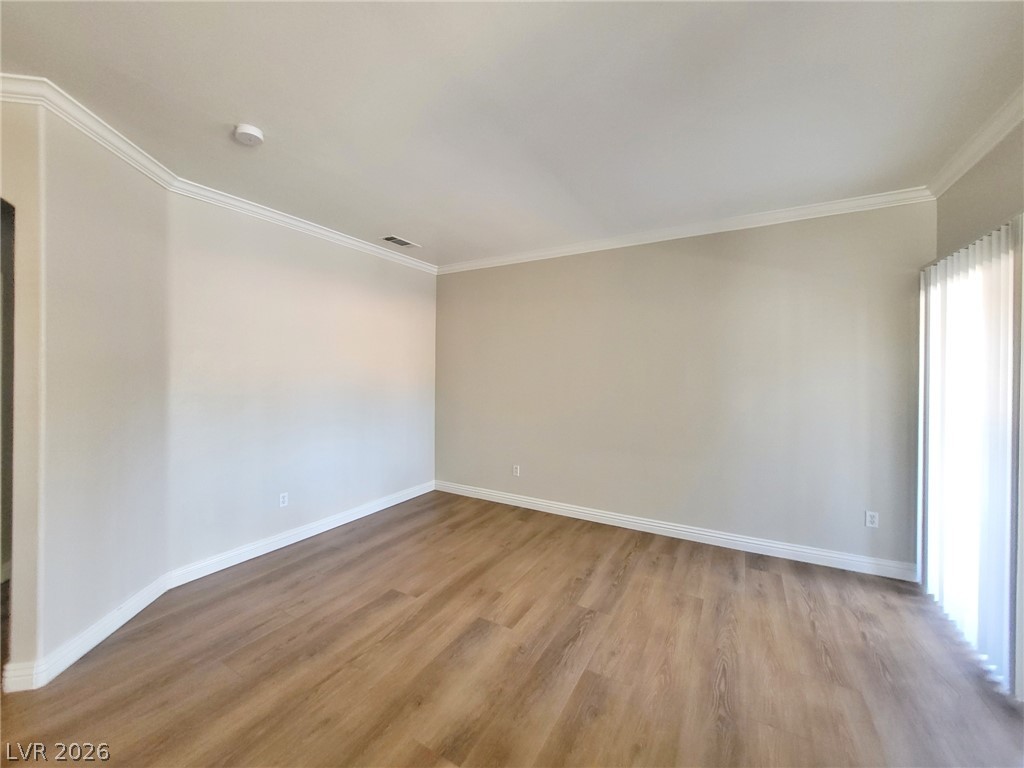 5525 West Flamingo Road, Unit 2040 Las Vegas, NV 89103 - Photo 2 of 15 Streamlined living space featuring durable laminate flooring and crisp crown molding.