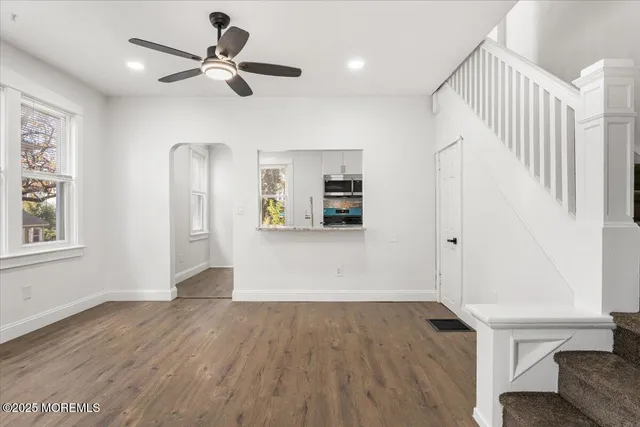 a view of a livingroom with wooden floor and a ceiling fan