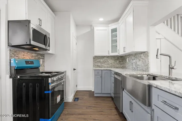 a kitchen with stainless steel appliances granite countertop a stove microwave and sink